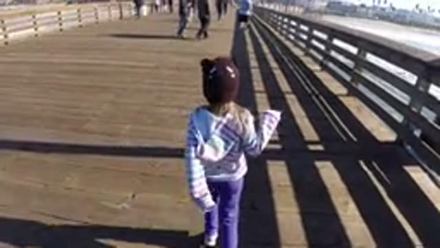 PISMO BEACH CALIFORNIA-2019: Young Girl Skipping Down Wooden Boardwalk