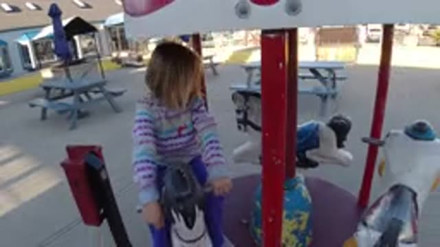 PISMO BEACH CALIFORNIA-2019: Girl Wearing Purple Pants Rides Miniature Merry-Go-Round