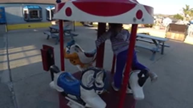 PISMO BEACH CALIFORNIA-2019: Toddler Playing On A Playground Carousel