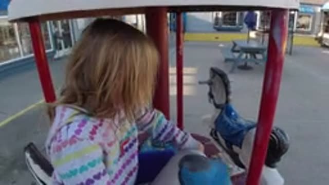 PISMO BEACH CALIFORNIA-2019: A Little Girl Rides The Duck On A Small Three