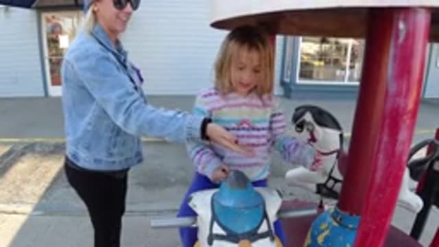 PISMO BEACH CALIFORNIA-2019: Happy Little Girl Playing In A Small Carousel With