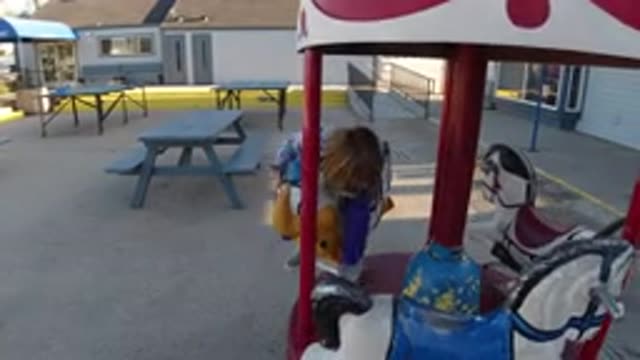 PISMO BEACH CALIFORNIA-2019: Young Blonde Girl Playing On A Carousel In The Yard