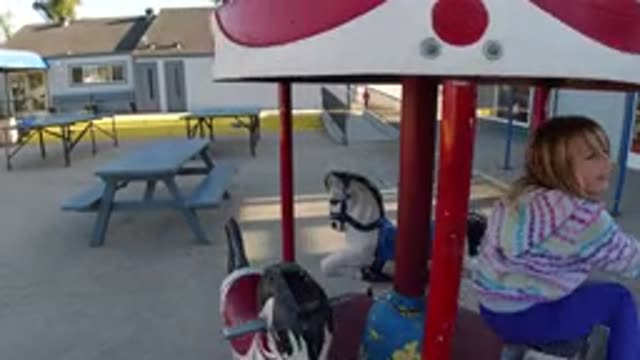 PISMO BEACH CALIFORNIA-2019: Child In A Rainbow Hoodie On A Horse Going Around