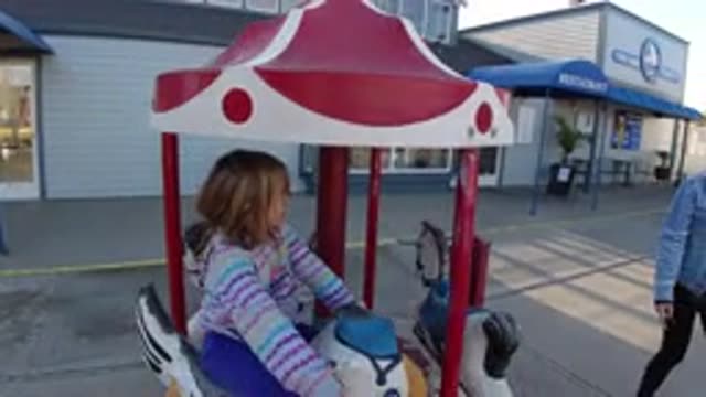 PISMO BEACH CALIFORNIA-2019: Mom And Daughter Playing On Merry Go Round
