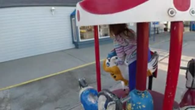 PISMO BEACH CALIFORNIA-2019: Little Girl Plays On A Coin Operated Child Sized Carousel