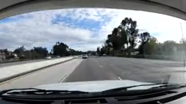 MALIBU CALIFORNIA-2019: Car Traveling On A Busy Tree-Lined Paved Road
