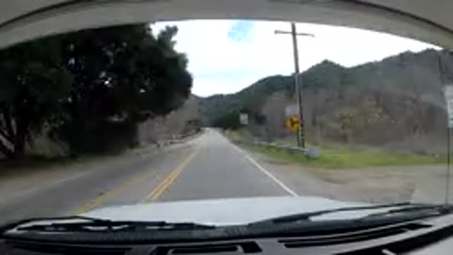 MALIBU CALIFORNIA-2019: Vehicle Moves Down Road Through Tunnel in Vintage 8mm Film