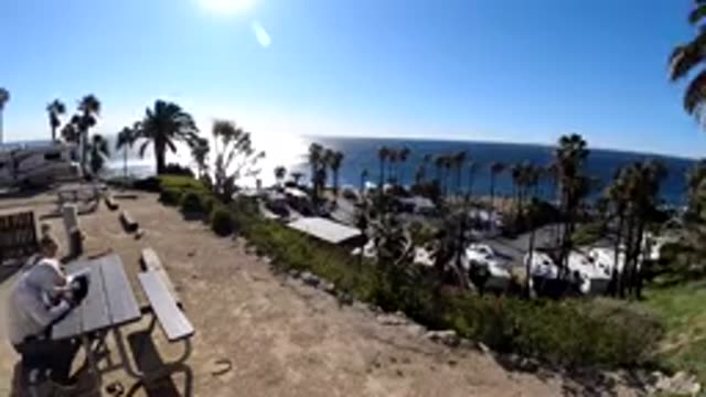 MALIBU CALIFORNIA-2019: Two People Sit And Relax On A Bench On A Windy Day