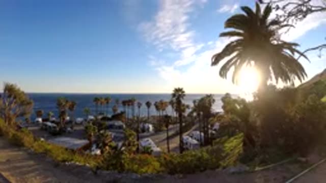 MALIBU CALIFORNIA-2019: Time Lapse Showing The Ocean With Motorhomes Parked And Palm Trees Blowing In The Wind