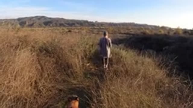 SAN CLEMENTE CALIFORNIA-2019: A Woman Walking Through A Grassy Meadow