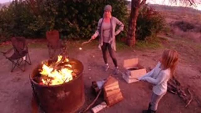 SAN CLEMENTE CALIFORNIA-2019: Mom And Daughter Standing Around A Campfire