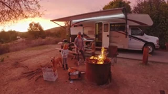 SAN CLEMENTE CALIFORNIA-2019: Grey Barrel Fire Near White Camper On A Clear Day