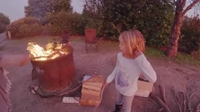 SAN CLEMENTE CALIFORNIA-2019: Adult And Child At A Campsite Poking At A Fire