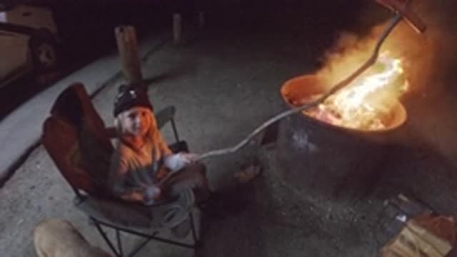 SAN CLEMENTE CALIFORNIA-2019: Young Kid Seated In A Chair Outside Making A Hot Dog