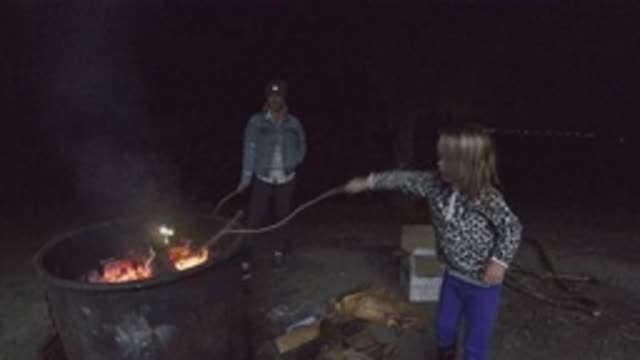 SAN CLEMENTE CALIFORNIA-2019: On A Cool Night A Little Girl Strokes A Campfire