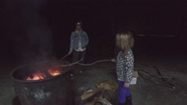 SAN CLEMENTE CALIFORNIA-2019: Child Has Fun Playing With His Father During A Nighttime Firelight Gathering