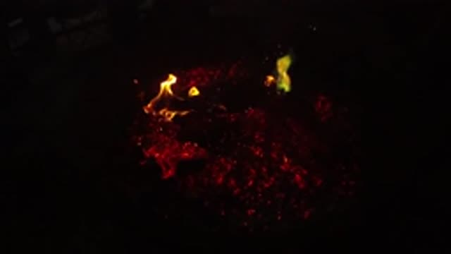 SAN CLEMENTE CALIFORNIA-2019: Flame Flaring Up From The Burning Coals Of A Dying Fire