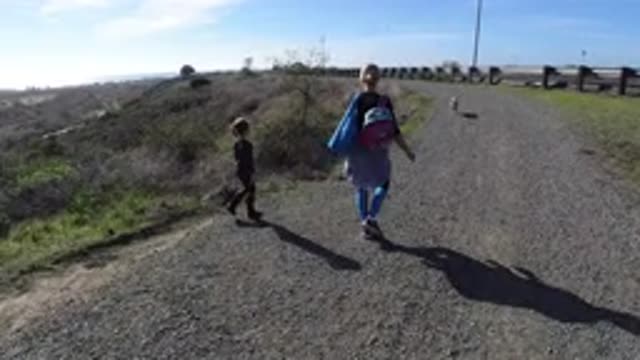SAN CLEMENTE CALIFORNIA-2019: Two People Walking Along The Side Of The Road With