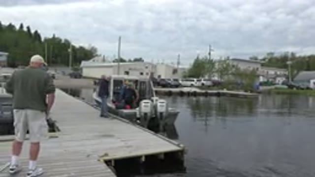 RED LAKE CANADA-2015: People Packing A Boat On A Lake With Homes Around