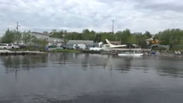 RED LAKE CANADA-2015: Lake Houses With Seaplanes And Cars Surrounded By Green