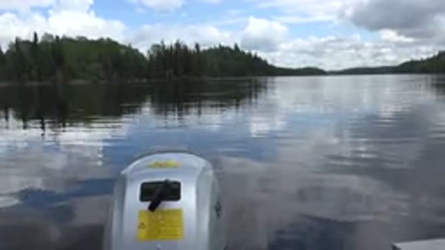 RED LAKE CANADA-2015: Motorboat In A River With Reflective Water And Trees