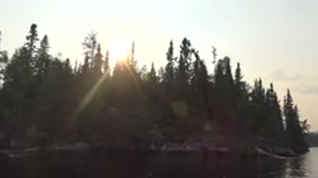RED LAKE CANADA-2015: Gentle Waters In Front Of A Forest Island With The Sun