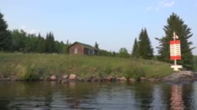 RED LAKE CANADA-2015: A Small House Beside The Lake Surrounded By Trees And