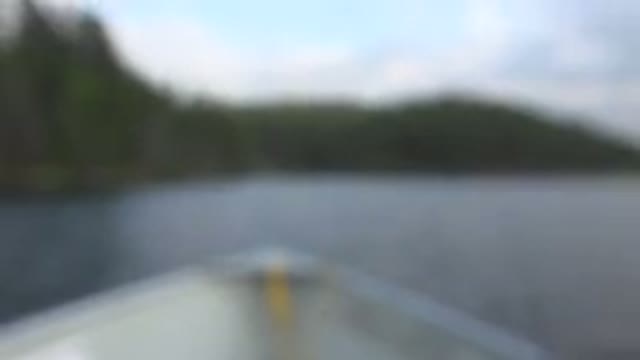 RED LAKE CANADA-2015: Fishing Pole On Side Of Boat On Body Of Water Out Of Focus