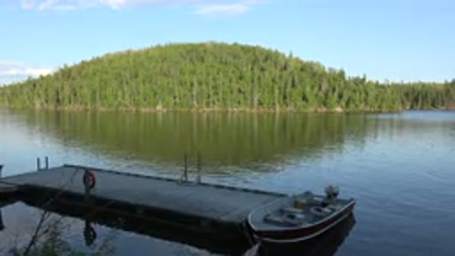 RED LAKE CANADA-2015: A Boat On A Lake And A Nearby Island Full Of Trees