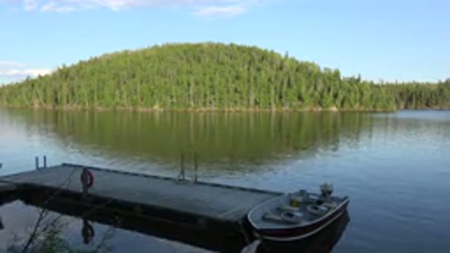 RED LAKE CANADA-2015: Pier On A Lake Overgrown With A Fishing Boat Ready For The