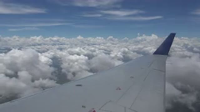 WINNIPEG CANADA-2015: Wing Of An Airplane Flying Above The Clouds During The Day