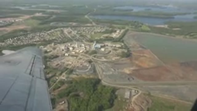 RED LAKE CANADA-2015: Airplane Hovering Over Buildings And A Forest
