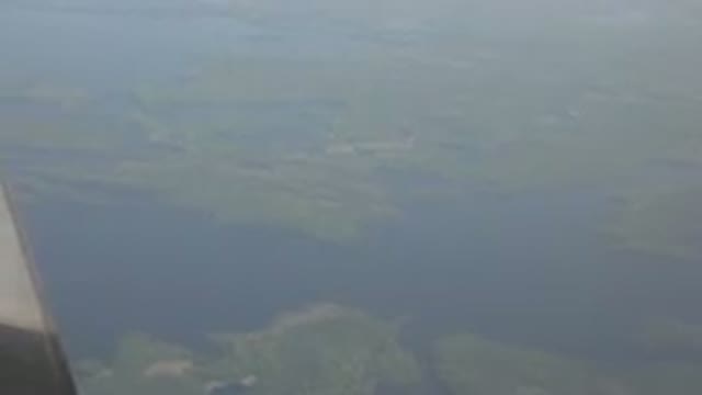 RED LAKE CANADA-2015: Water And Green Land Masses Outside Airplane Window