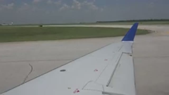 WINNIPEG CANADA-2015: A White Airplane With A Blue Tipped Wing Taking Off