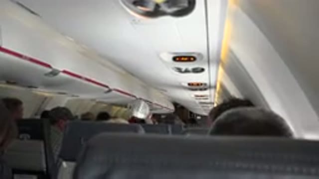 WINNIPEG CANADA-2015: View From Inside Airplane Of Passengers In Rows Ahead Man