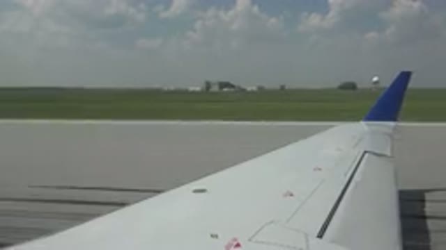 WINNIPEG CANADA-2015: A White Airplane Wing With A Blue Tip Speeding Down A Runway