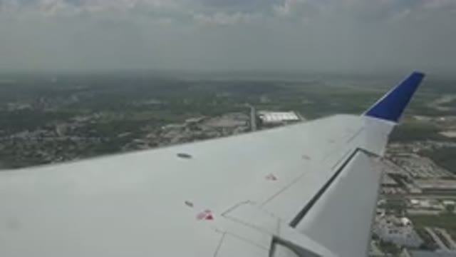 WINNIPEG CANADA-2015: Airplane Flying Over Green Field With Wing Visible
