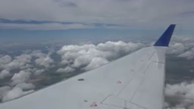 WINNIPEG CANADA-2015: A Plane Wing With A Blue Tip In Front Of Fluffy Clouds