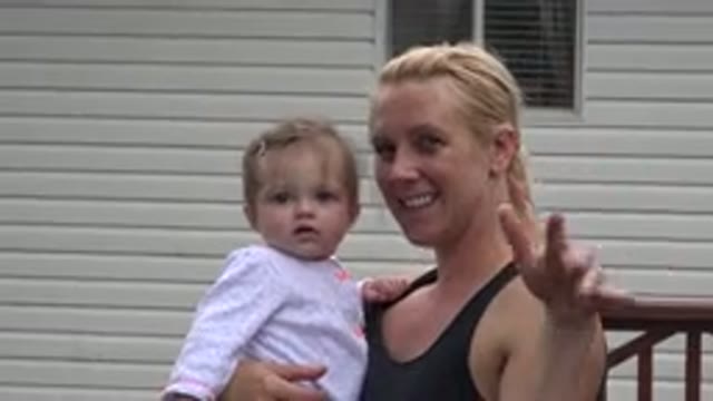 WESTMINSTER COLORADO-2015: A Mother Kissing Her Baby Daughter While Someone Is