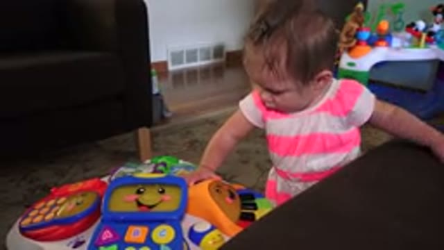 WESTMINSTER COLORADO-2015: A Child In A Pink Stripe Dress Is Standing And Playing With Colorful Toys