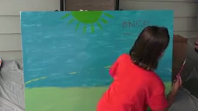 BROOMFIELD COLORADO-2015: A Female In An Orange Shirt Painting On Canvas