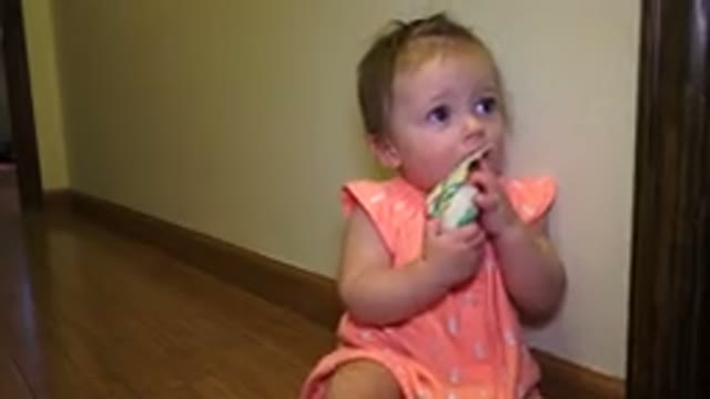 BROOMFIELD COLORADO-2015: Small Baby In A Pink Outfit Plays With A Toy And Tries To Eat It