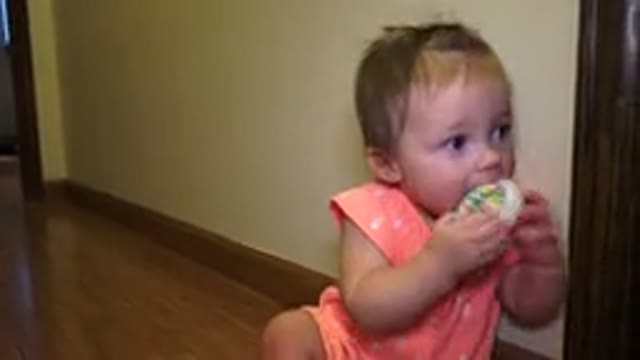 BROOMFIELD COLORADO-2015: Toddler In Orange Dress Chewing On A Rolled Up Pair Of Socks