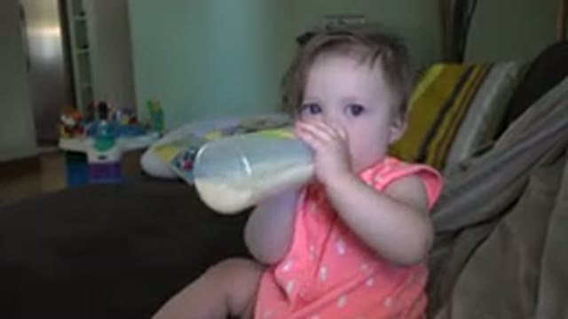 BROOMFIELD COLORADO-2015: Cute Beautiful Toddler Feeding From A Bottle While Sitting On Bed