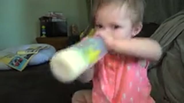 BROOMFIELD COLORADO-2015: A Baby Drinking A Bottle Of Milk While She Bounces On