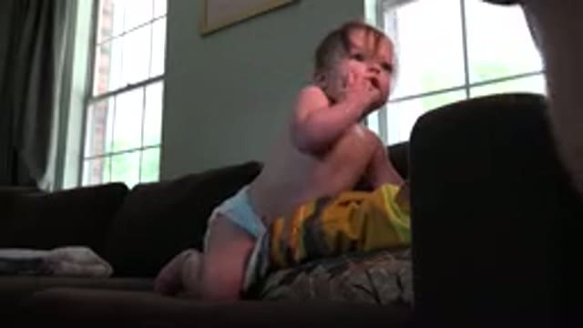 WESTMINSTER COLORADO-2015: White Baby Playing On The Dark Living Room Sofa While