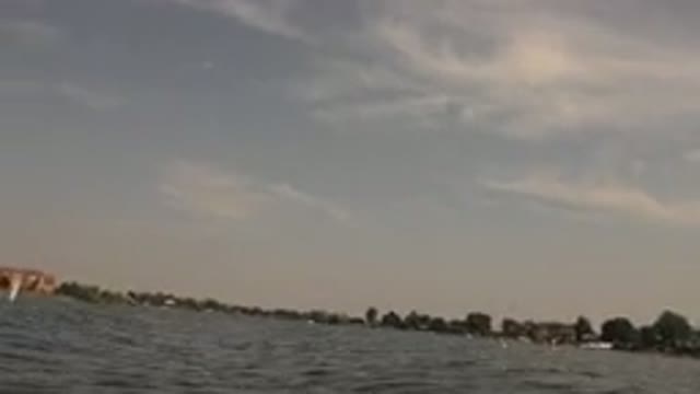 HIDDEN LAKE COLORADO-2015: Person Floating On Lake With Small Brown Dog