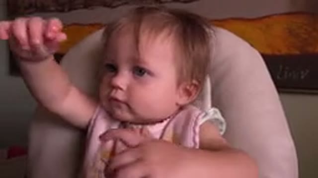 HIDDEN LAKE COLORADO-2015: Baby Sitting In A Chair Raising Her Arms And Then Putting Hand To Mouth