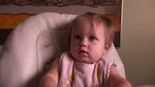 HIDDEN LAKE COLORADO-2015: A Blond Baby Boy With Blue Eyes Sitting On The Pink Chair