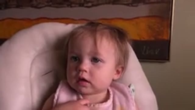 HIDDEN LAKE COLORADO-2015: Serious Baby Girl With Bib Sitting In High Chair